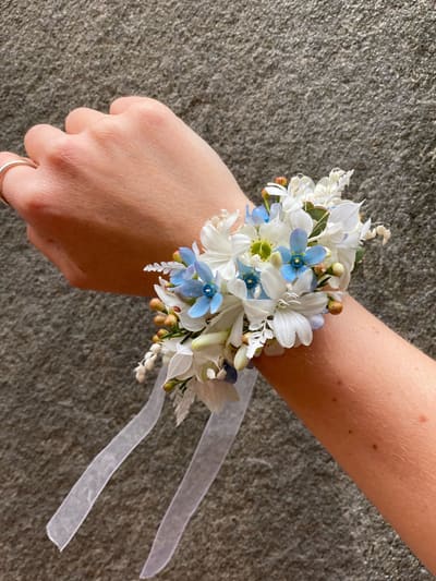 Håndleddskorsasje med små lyse blomster og silkebånd