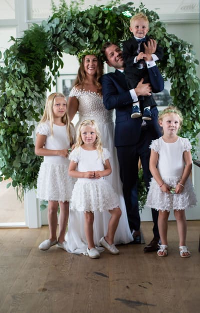 Brudefølge med barn under en blomsterbue