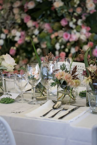 Langbord dekket med blomsterdekorasjoner og levende lys