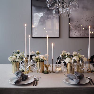 Dekket bord med lys og blomster.